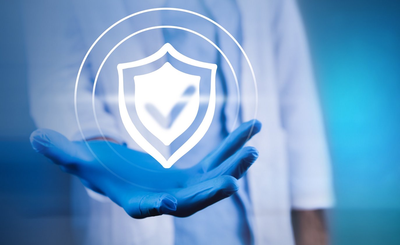 Hand in blauer Schutzhandschuh hält ein digitales Schildsymbol – steht für Sicherheit und Schutz.
